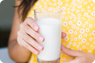 Person holding a glass of milk