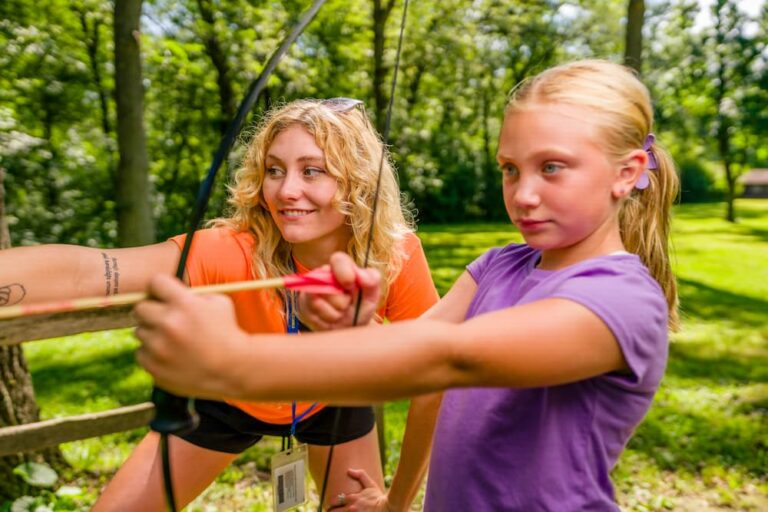 Counselor teaching Camper Archery at Camp Double Eagle, part of the YMCA of Greater Waukesha County