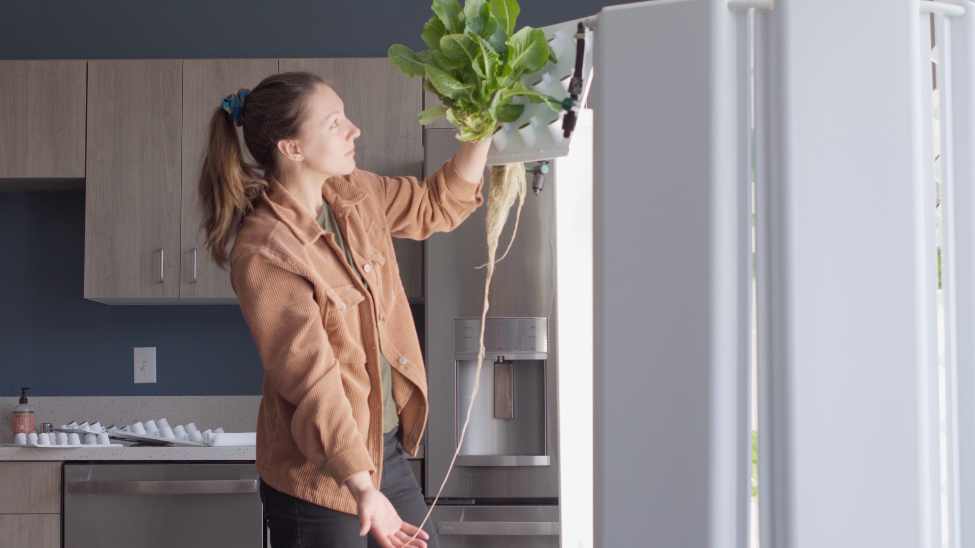 Association Director of Healthy Living holding produce grown using a hydroponic garden